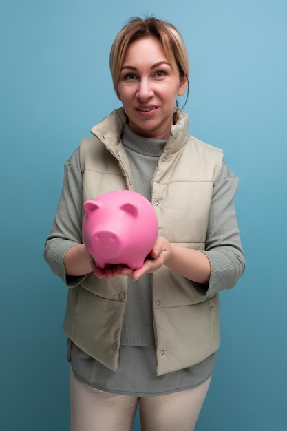 Young blond hair woman keeps her money in a money box