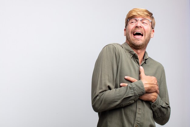 Young blond man happy and smiling. satisfied expression