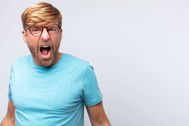 Young blond man shouting and angry