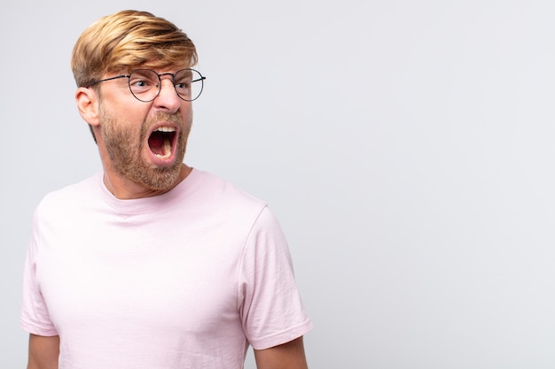 Young blond man shouting and angry