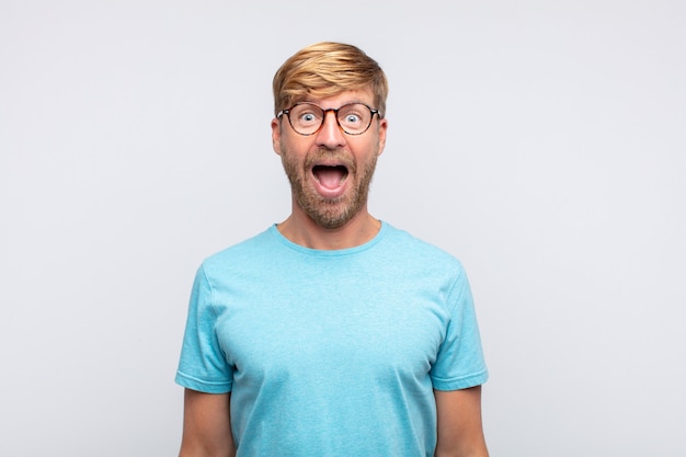 Young blond man surprised or shocked