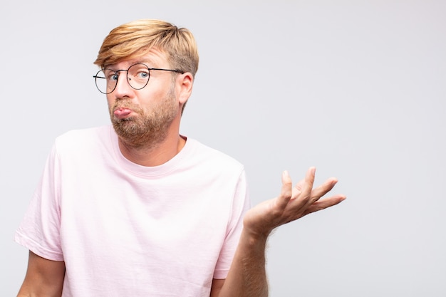 Young blond man thinking  or doubting