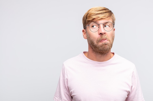 Photo young blond man thinking  or doubting