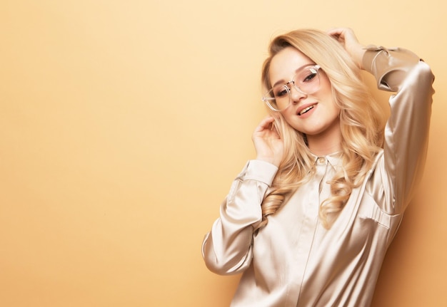 Young blond woman in blouse and pants wearing sunglasses