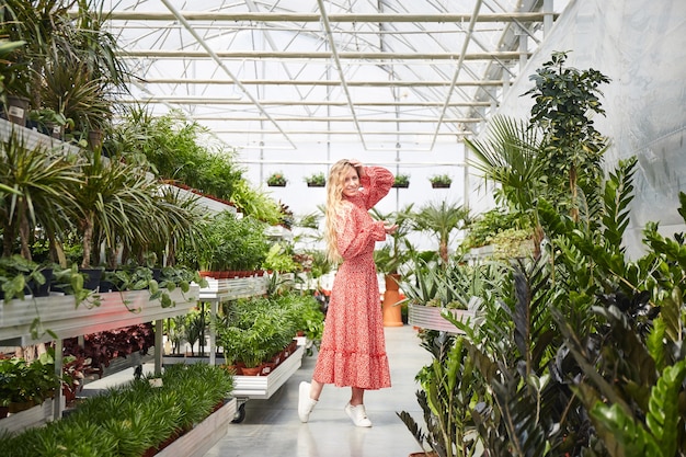 Young blond woman in a greenhouse