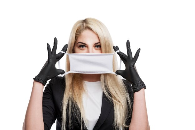 Young blond woman in medical mask and gloves. Isolated on white background