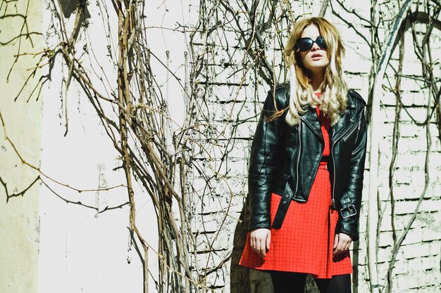 Young blond woman wearing red dress posing in the city