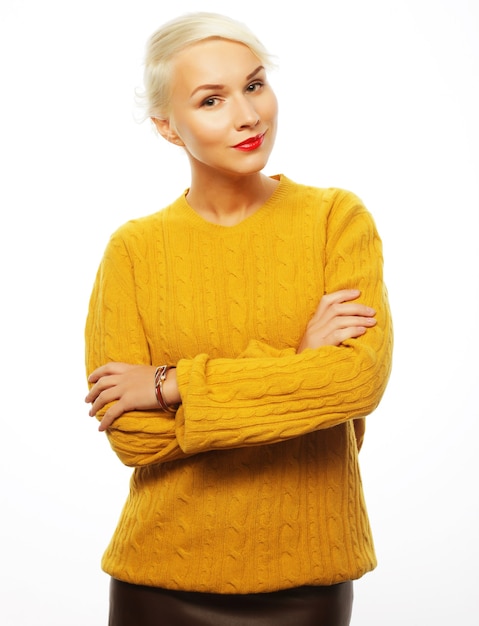 Young blond woman wearing yellow sweater isolated on white