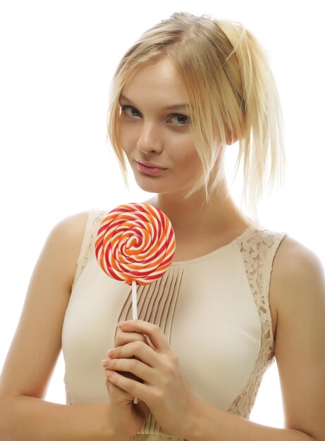Молодая блондинка женщина с конфетой, изолированные на белом фоне