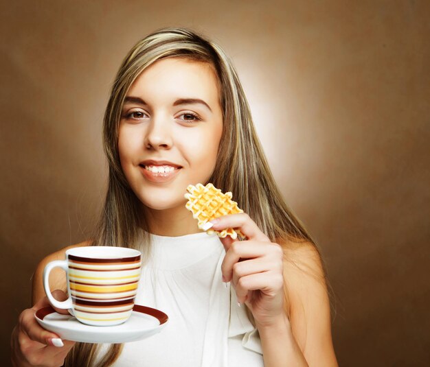 Молодая блондинка женщина с кофе и печеньем