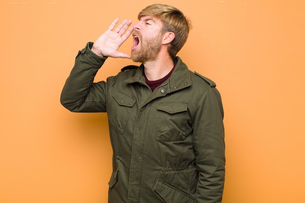 young blonde bearded man yelling loudly and angrily