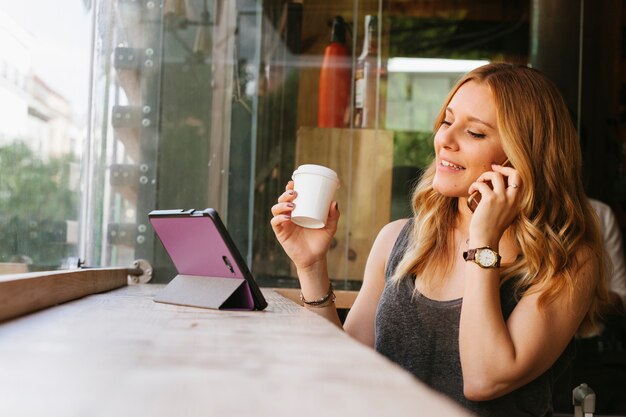 Young blonde blogger using technology devices