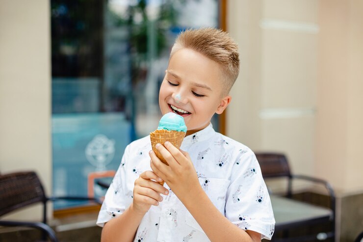 Young blonde boy with ice cream in his hands