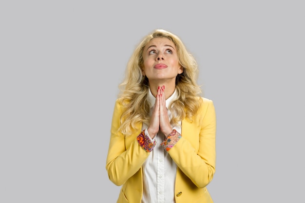 Young blonde business woman praying