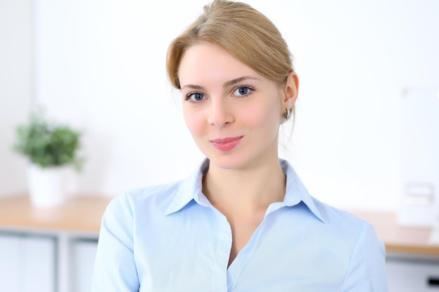 Young blonde business woman with laptop in the office. Business concept.