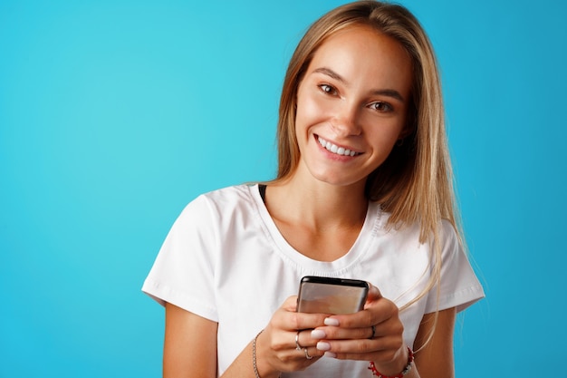 Young blonde casual girl using her smartphone.