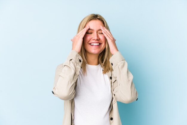 Young blonde caucasian woman isolated covers eyes with hands, smiles broadly waiting for a surprise.