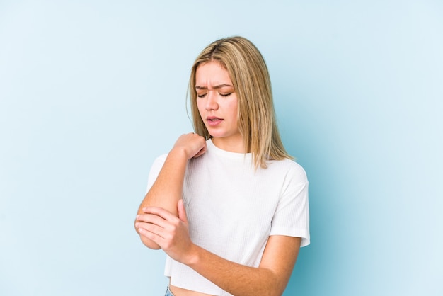 young blonde caucasian woman isolated massaging elbow, suffering after a bad movement.