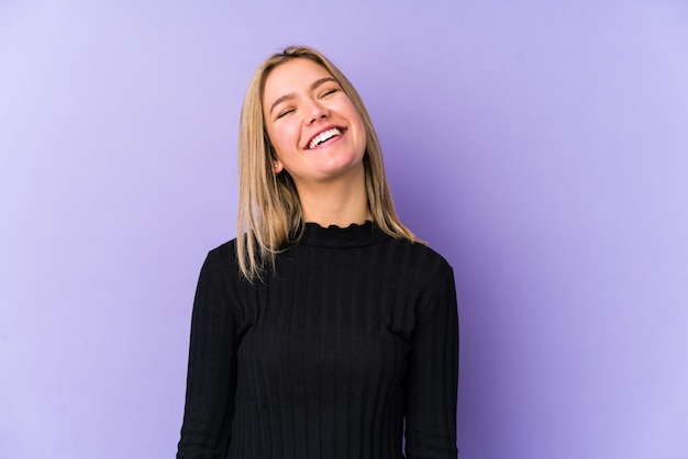 Young blonde caucasian woman isolated relaxed and happy laughing, neck stretched showing teeth.