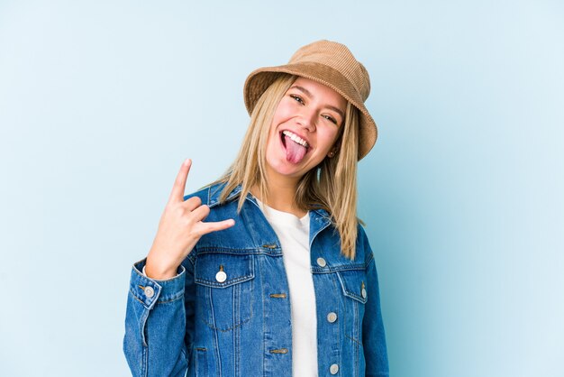 Young blonde caucasian woman isolated showing rock gesture with fingers