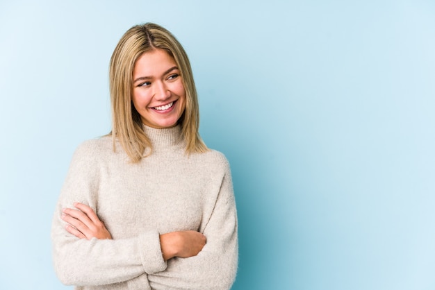 Young blonde caucasian woman isolated smiling confident with crossed arms.