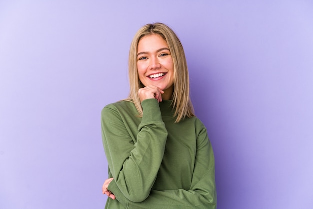 Young blonde caucasian woman isolated smiling happy and confident, touching chin with hand.