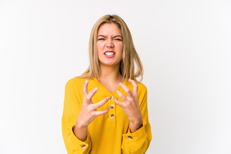 Photo young blonde caucasian woman isolated upset screaming with tense hands.