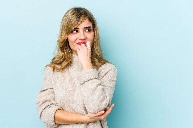 Young blonde caucasian woman relaxed thinking about something looking at a copy space.