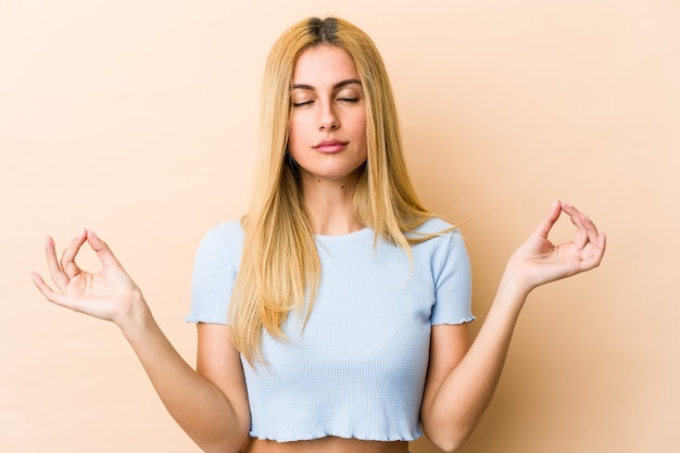 Young blonde caucasian woman relaxes after hard working day, she is performing yoga.