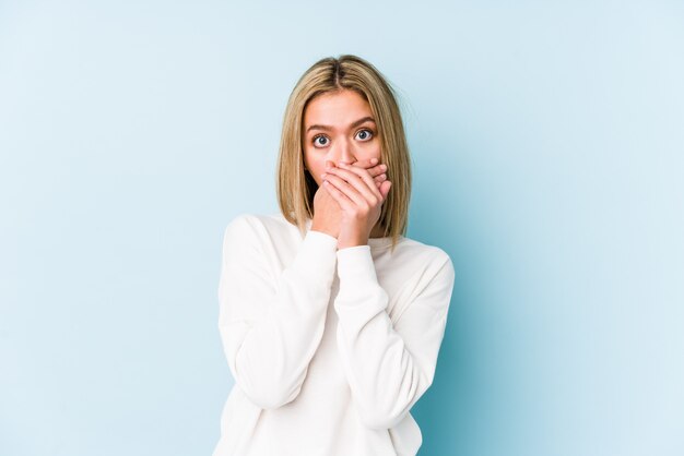 Young blonde caucasian woman shocked covering mouth with hands.