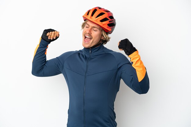 Young blonde cyclist man isolated celebrating a victory