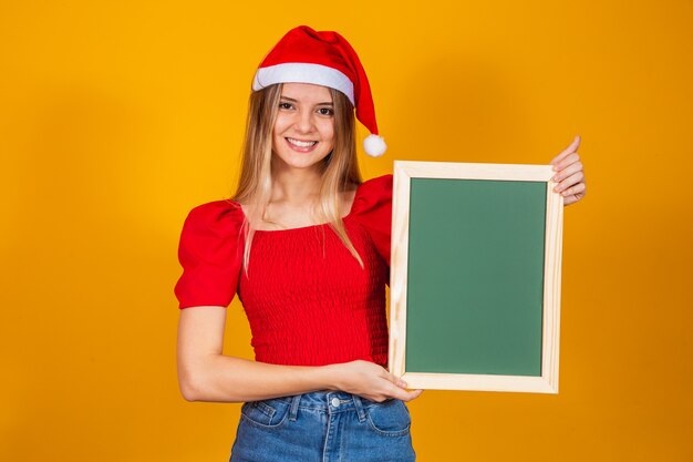 Young blonde dressed for christmas holding a placard. Christmas