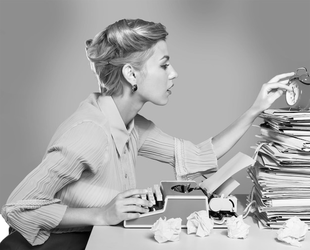 Young blonde female writer using typing machine, black and\
white portrait