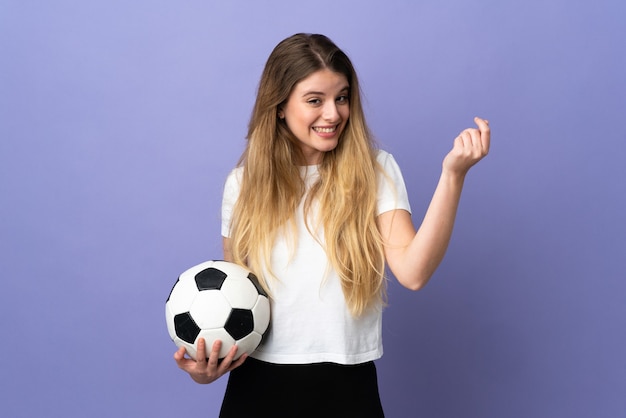 Young blonde football player woman on purple making money gesture