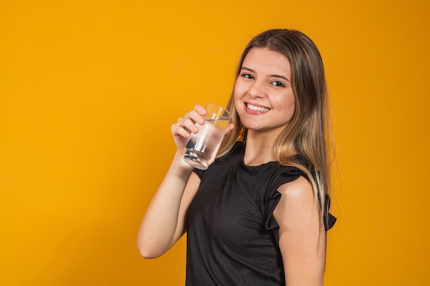 Giovane ragazza bionda che si idrata bevendo acqua