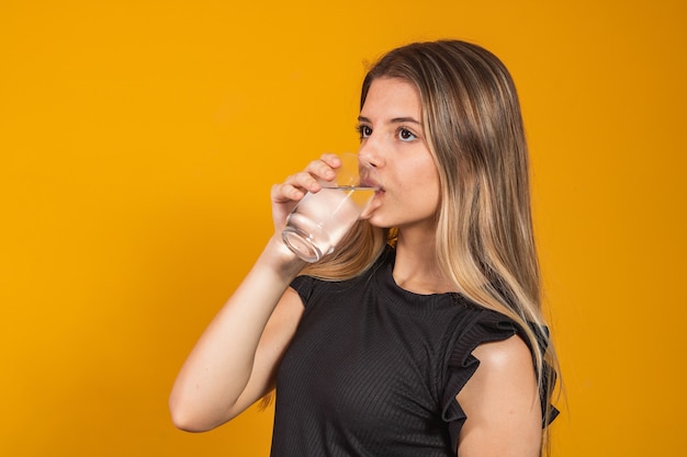 Young blonde girl getting hydrated drinking water