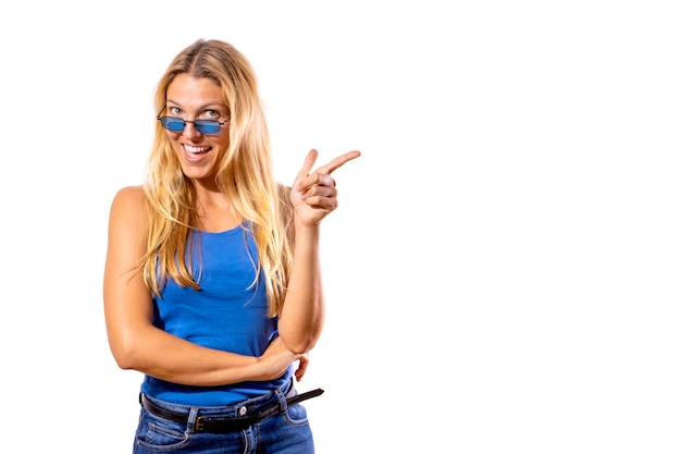 Young blonde girl on white background and casual blue tshirt pointing her finger in one direction