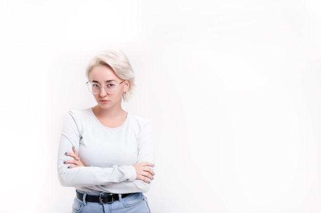 Photo a young blonde girl on a white background folded her hands