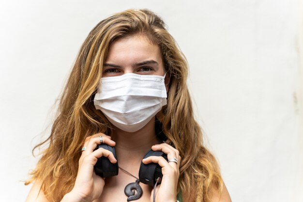 Young blonde girl with a mask on her face to protect her from viruses