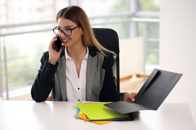 Young blonde girl working in the office