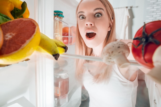 Young blonde at home near fridge