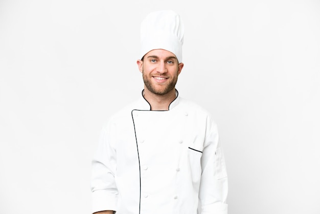 Young blonde man Chef over isolated white background laughing