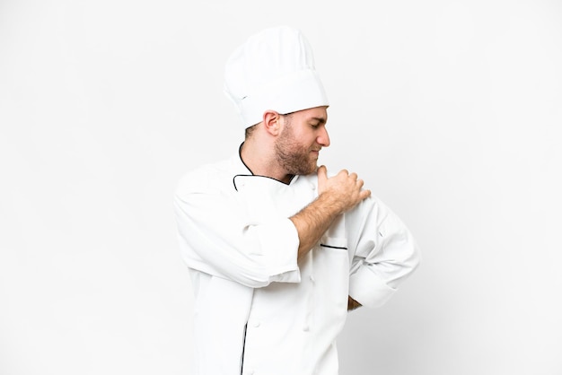 Young blonde man Chef over isolated white background suffering from pain in shoulder for having made an effort