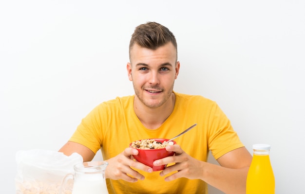 Young blonde man having breakfast