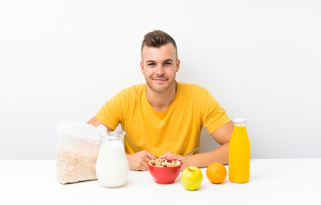 Young blonde man having breakfast