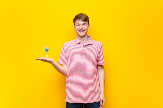 Young blonde man holding a sandclock timer