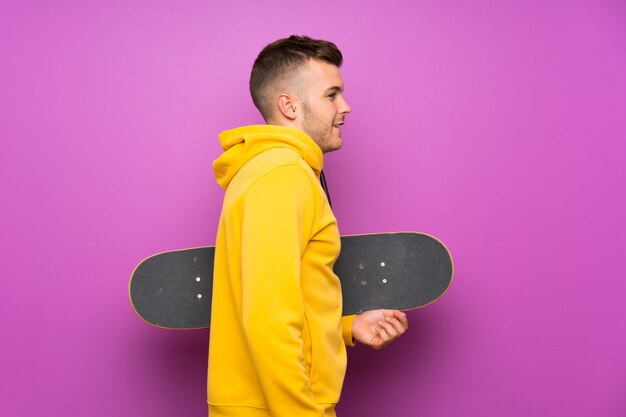 Young blonde man holding a skate