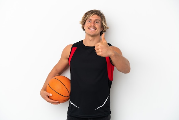 Young blonde man isolated on white background playing basketball and with thumb up