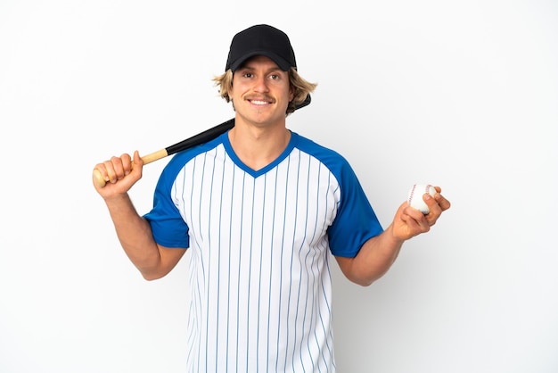 Young blonde man isolated on white wall playing baseball