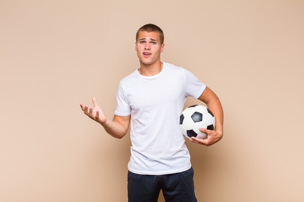 Photo young blonde man looking desperate and frustrated, stressed, unhappy and annoyed, shouting and screaming